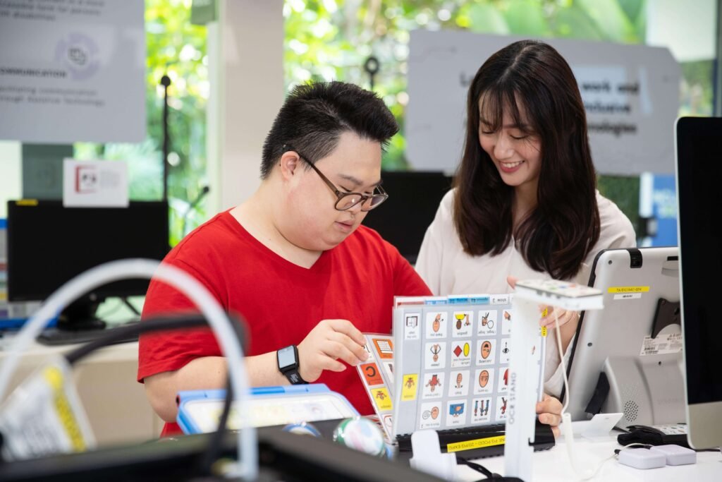 Communication Support in Positive Behaviour Support Support worker using visual communication cards with a person with disability